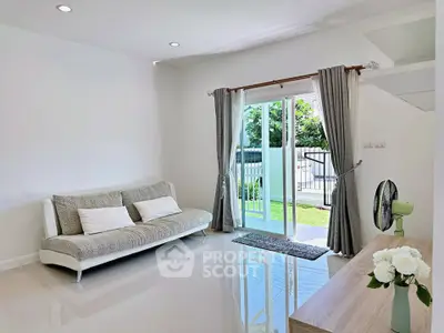 Bright modern living room with sleek sofa and garden view through glass doors