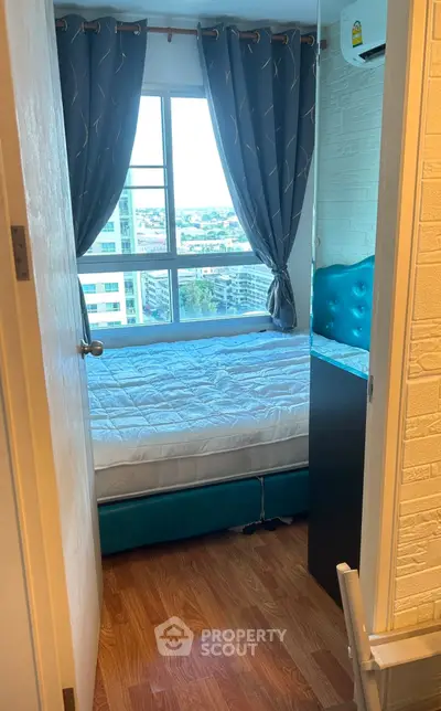 Cozy bedroom with city view, featuring a comfortable bed and stylish curtains.