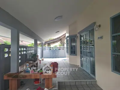 Charming covered patio with tiled flooring and blue accents, perfect for outdoor relaxation.