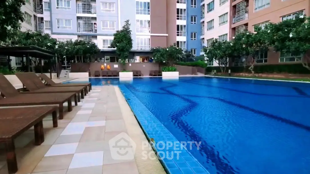 Luxurious apartment complex with stunning outdoor pool and lounging area.