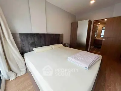 Spacious bedroom with modern decor and ensuite bathroom in a stylish apartment.