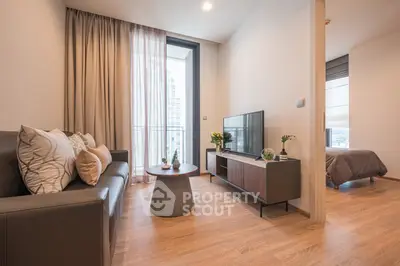 Modern living room with sleek furniture and natural light, adjacent to a cozy bedroom.