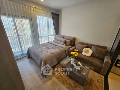 Cozy bedroom with stylish decor and large windows offering city views.