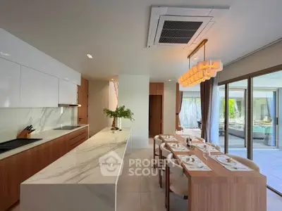 Luxurious modern kitchen with marble countertops and open layout, featuring elegant dining area and large windows.