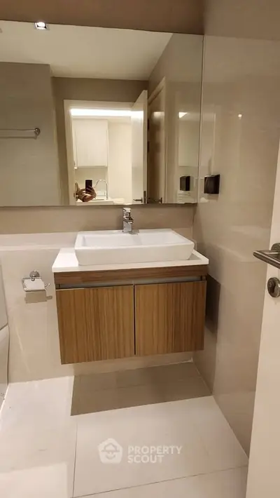 Modern bathroom with sleek vanity and mirror in a contemporary apartment.
