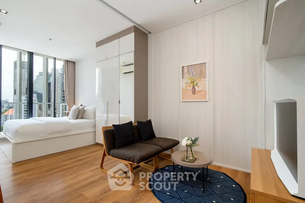 Modern studio apartment with stylish decor and city view, featuring cozy living area and elegant bedroom.