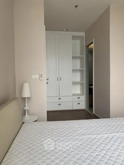 Cozy bedroom with built-in wardrobe and elegant bedside lamp