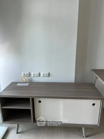 Modern minimalist wooden cabinet with sliding doors in a bright interior space.