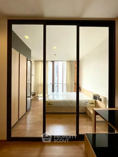 Spacious modern bedroom with floor-to-ceiling windows and elegant wooden flooring.