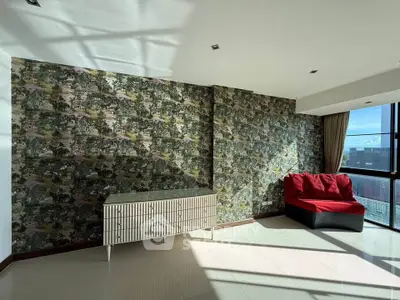Spacious living room with unique wallpaper and modern furniture, featuring large windows for natural light.