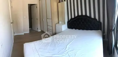 Spacious bedroom with elegant headboard and striped accent wall