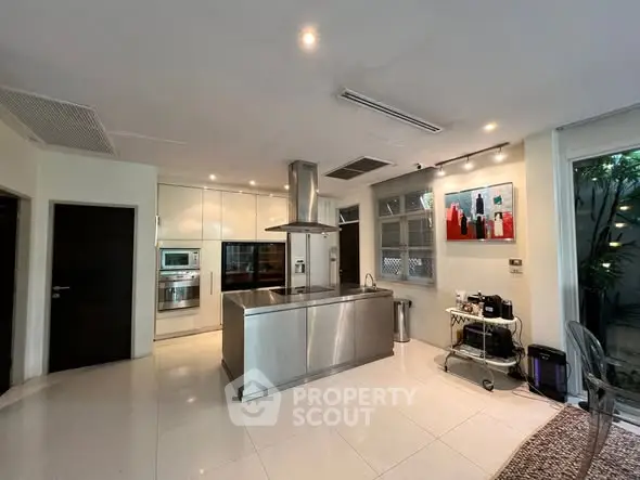 Modern kitchen with sleek stainless steel island and contemporary decor.