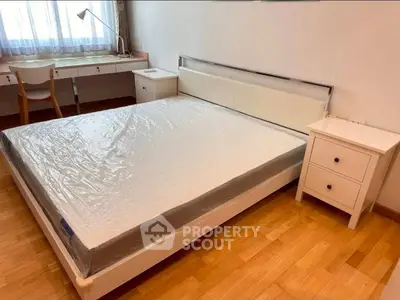 Spacious bedroom with modern furniture and natural light, perfect for relaxation and comfort.