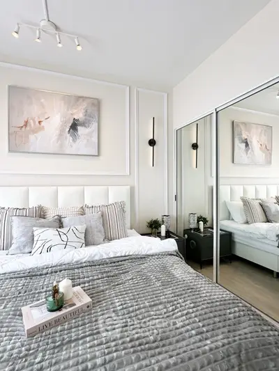 Luxurious modern bedroom with elegant decor and mirrored closet doors