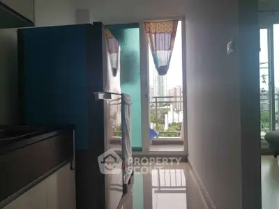 Modern kitchen with balcony view and sleek appliances in urban apartment