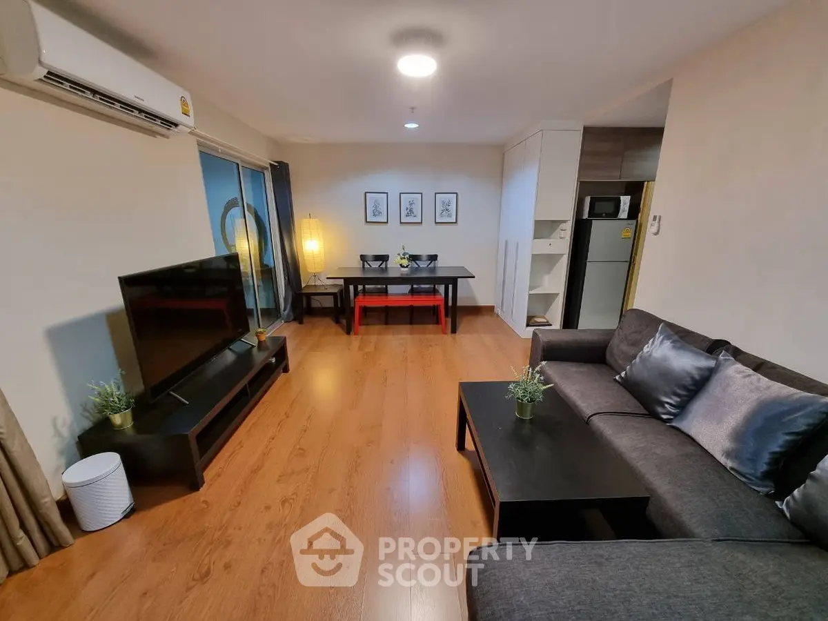 Spacious modern living room with sleek furniture and wooden flooring, perfect for relaxation and entertainment.