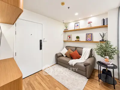 Cozy living room with modern decor and wooden flooring, featuring a comfortable sofa and stylish shelving.