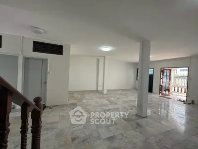 Spacious open-plan living area with marble flooring and ample natural light