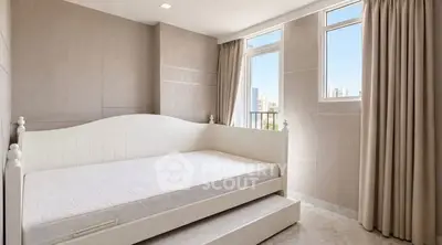 Bright bedroom with trundle bed and large windows offering city views.