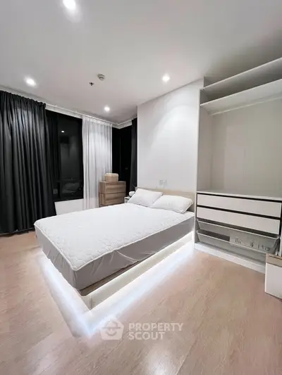 Modern bedroom with sleek design and ambient lighting, featuring a minimalist bed and spacious wardrobe.