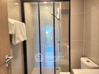 Modern bathroom with glass shower enclosure and sleek fixtures