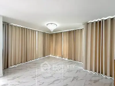 Spacious corner unit with elegant marble flooring and modern chandelier, perfect for stylish living.