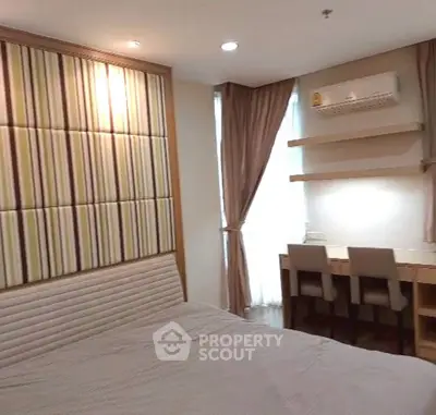 Modern bedroom with stylish headboard and study area, featuring elegant curtains and ambient lighting.