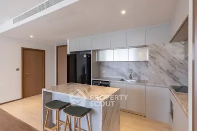 Modern kitchen with marble island and sleek cabinetry in a contemporary apartment.