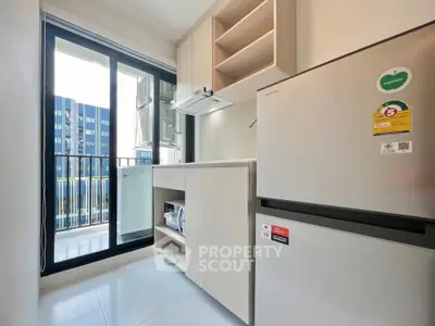 Modern kitchen with sleek appliances and balcony view in urban apartment