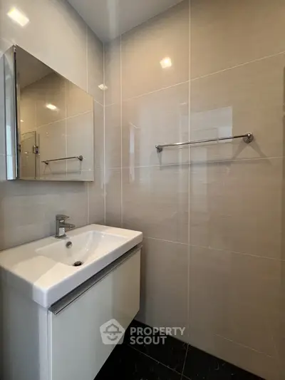 Modern bathroom with sleek sink and large mirror in contemporary design.