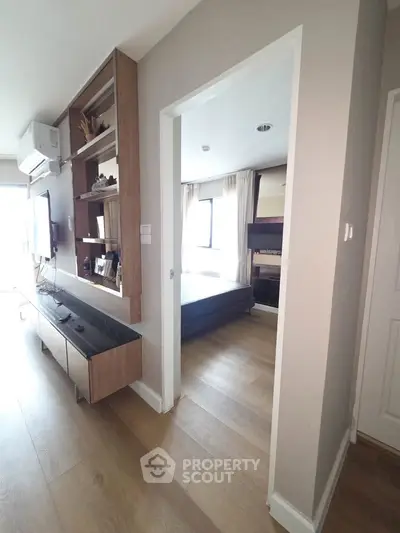 Modern apartment interior with open layout, featuring a cozy living room and a glimpse into a stylish bedroom.