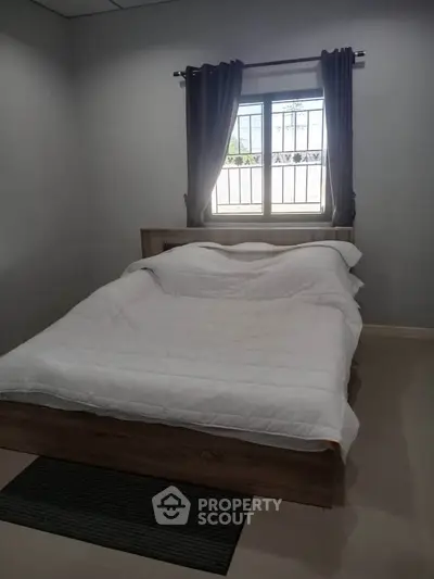 Cozy bedroom with modern bed and window view, perfect for relaxation.
