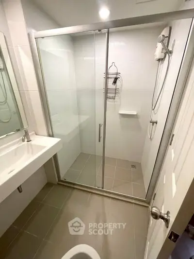 Modern bathroom with glass shower enclosure and sleek fixtures