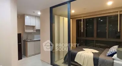 Modern studio apartment with open layout, featuring a cozy bedroom and compact kitchen area.