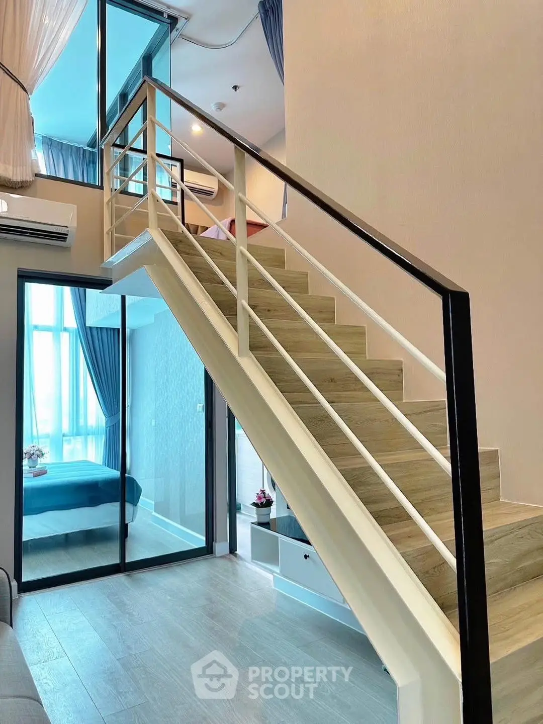 Modern duplex apartment with stylish staircase and bright interior design.