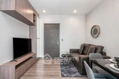 Modern living room with sleek furniture and wall-mounted TV in a stylish apartment.