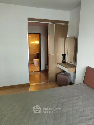 Modern bedroom with ensuite bathroom featuring sleek wooden furniture and contemporary design.