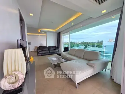 Spacious modern living room with large windows and elegant furnishings, offering a stunning view.