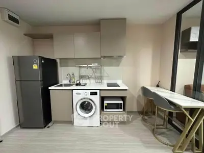 Modern kitchen with integrated washing machine and sleek appliances in a compact layout.
