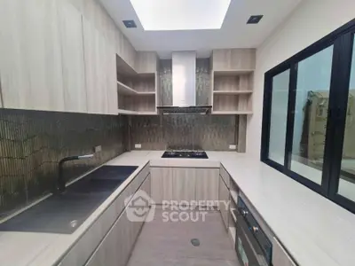 Modern kitchen with sleek cabinetry and gas stove in contemporary home.