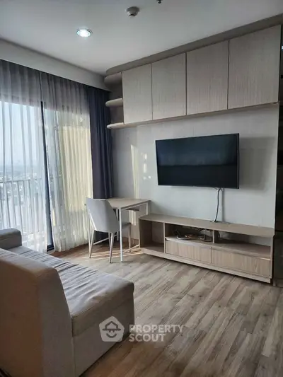 Modern living room with sleek furniture and large window offering natural light and city view.