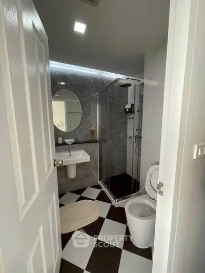 Modern bathroom with glass shower and checkered floor tiles