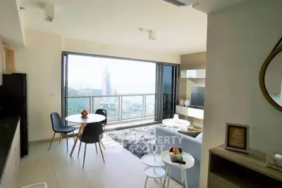 Modern living room with stunning city view and open balcony, featuring stylish furniture and decor.