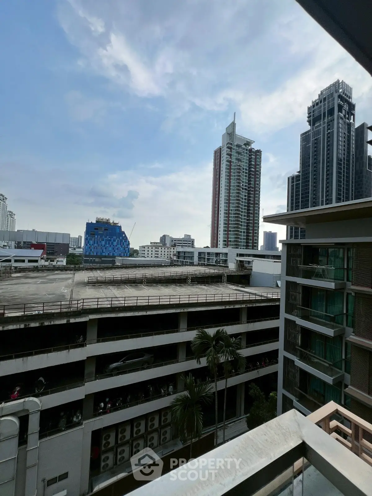 Stunning urban view from a high-rise balcony overlooking city skyline and modern architecture.