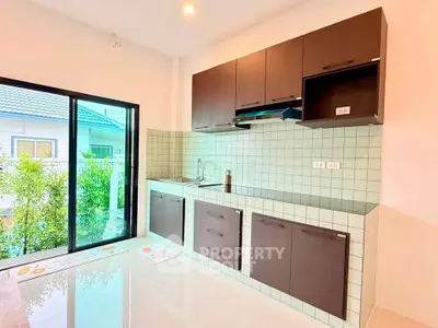 Modern kitchen with sleek cabinets and large window overlooking garden