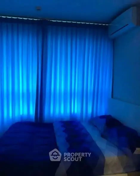 Cozy bedroom with ambient blue lighting and air conditioning, perfect for relaxation.