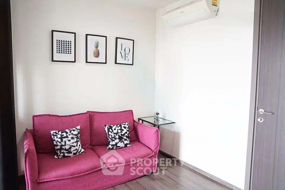Chic living room with vibrant pink sofa and modern wall art, perfect for stylish urban living.