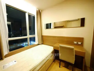 Cozy bedroom with city view, featuring a single bed and study desk, perfect for urban living.
