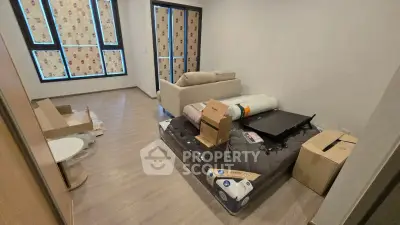 Unfurnished room with large windows and unpacked boxes, ideal for customization.