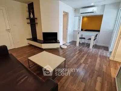 Modern living room with sleek furniture and wooden flooring in a stylish apartment.